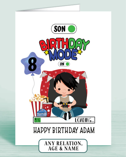 Birthday card with a cartoon boy with Black Hair, popcorn, and video game controller & a blue birthday balloon with age 8 as example.